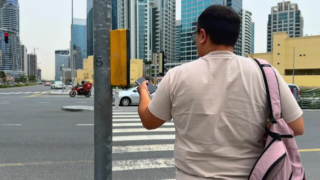 person walking in the city, A man stands on a zebra crossing waiting for a green signal
