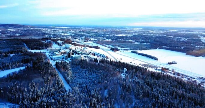 Aerial Panning Descending Scenic View Of Buildings On Snowy Hill, Drone Flying Over Trees In Tranquil Forest - Fairbanks, Alaska