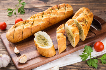 garlic baguette roll on a wooden cutting board