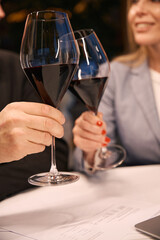 Female and male communicate over a glass of red wine