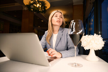 Lonely woman is working with documents in a restaurant hall