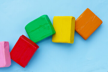 Colorful plasticine clay on blue background.