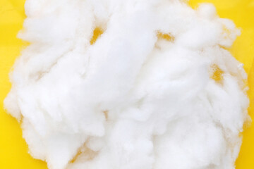 Polyester stable fiber on yellow background.
