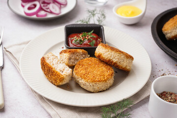 Plate with tasty meat cutlets and sauce on white background