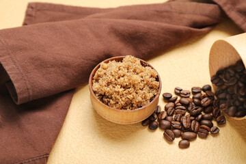 Bowl of natural body scrub, coffee beans and napkin on color background, closeup