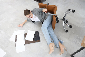 Young businesswoman fell down from chair in office. Trauma concept