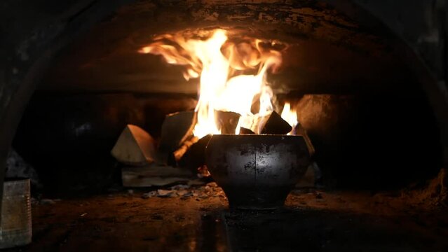 fire burning in the ukrainian oven  close-up. Ukrainian traditional dish. a traditional Ukrainian stove with a cast-iron pot, in which a very tasty dish is prepared on fire
