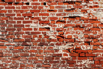 Texture of old destroyed red brick wall with remains of lime