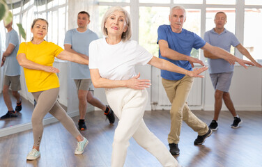 Group of aged people rehearsing sports dance in dance hall - obrazy, fototapety, plakaty