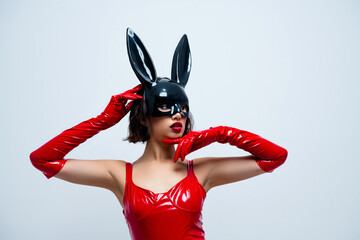 Photo of gorgeous girl touch face look empty space rabbit mask red leather outfit isolated on light...