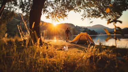 Man camping on the lake in the mountains at sunset. Camping in the mountains.