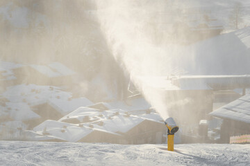 Schneekanonen beschneien die Piste mit Kunstschnee für Skifahrer und Snowboarder bei Frost im Winter.