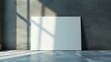 Blank white canvas mockup leaning against a textured concrete wall with sunlight and shadows on the background.