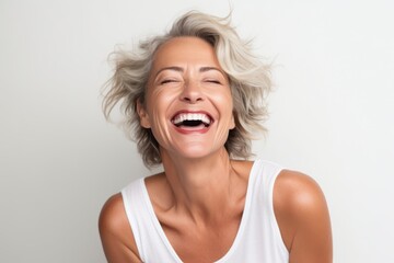 Portrait of a happy mature woman laughing on a white background.