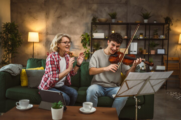 Young man learn how to play violin under instruction mature professor - obrazy, fototapety, plakaty