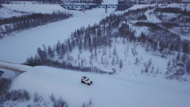 Car driving on snowy road far north landscape