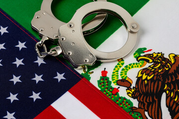 United States and Mexico flags with handcuffs. Border security, immigration reform and illegal...