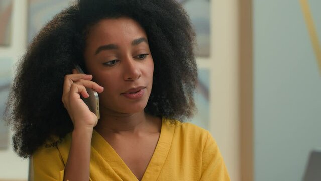 African American woman smiling ethnic businesswoman female manager business girl employer saleswoman talking mobile phone working with laptop in office smartphone call consult client talk communicate