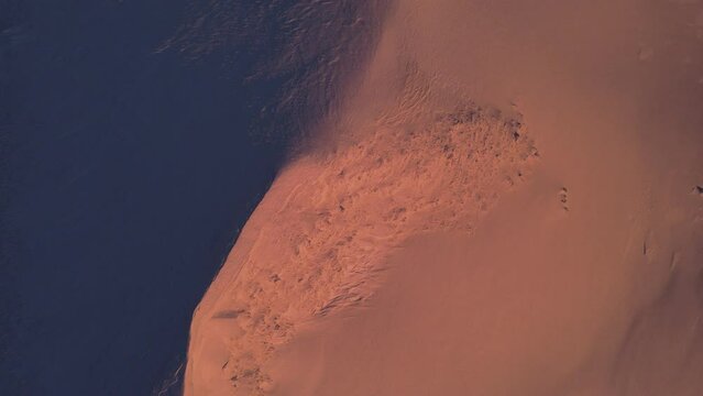Mountainous snowy terrain in the pink rays of the sun. Ariel drone view