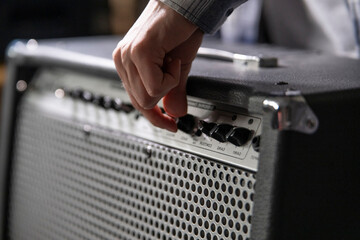 Guitarist Fine-Tunes Amplifier Settings Before a Performance in a Backstage Area - 766685119