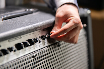 Guitarist Fine-Tunes Amplifier Settings Before a Performance in a Backstage Area - 766685120