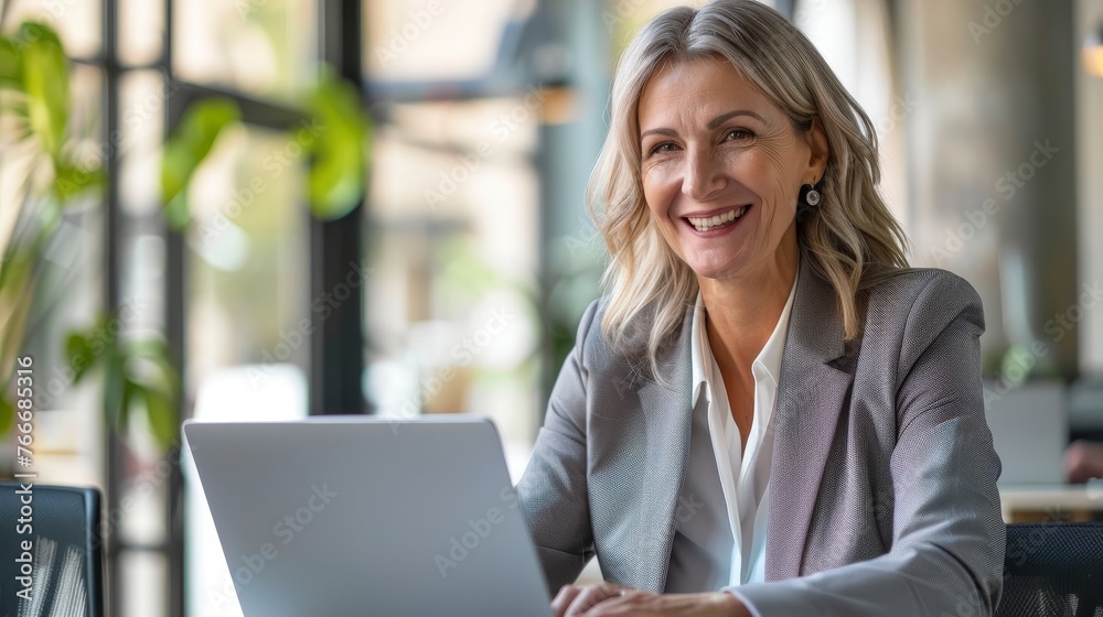 Wall mural happy mature business woman entrepreneur in office using laptop at work smiling professional middle 