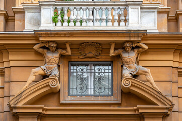 Two statues holding up the balcony in Rome, Italy