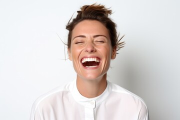 Portrait of a happy young woman laughing with closed eyes on white background