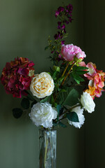 Colorful Silk Flower Arrangement, Elegant, Sophisticated in Glass Vase Against Soft Green Walls