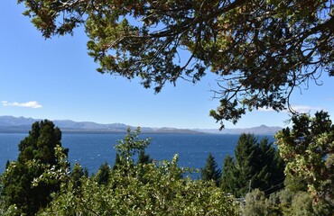 Fototapeta na wymiar Blue lake with a blue sky, montains and trees