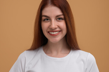 Portrait of smiling woman with freckles on beige background