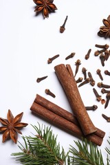 Different spices and fir branches on white table, flat lay