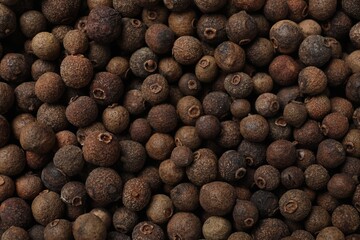 Aromatic allspice pepper grains as background, top view