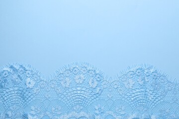 Beautiful lace on light blue background, top view. Space for text