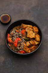 Fried Udon with Chicken and vegetables on dark brown background. Top view. Asian food.