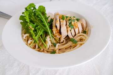 Asian dish garlic chicken noodle with fresh green leaves