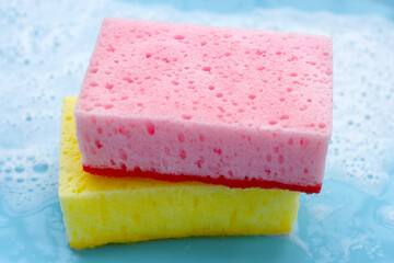 Cleaning sponge in foam of dishwashing liquid. Washing dishes concept