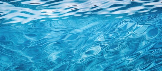 A detailed view of the surface of a body of water in a deep blue color, with small waves causing ripples