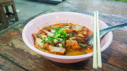 Tom Yum Yellow Noodles with Crispy Pork, Spicy Thai Noodle with egg and red bbq pork