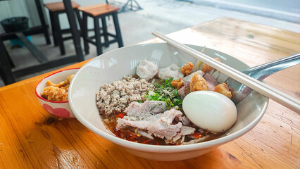 noodles with pork and meatballs in spicy soup or Tom yum noodles in Asian style