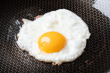 Fried egg in a pan for breakfast. Cooking.