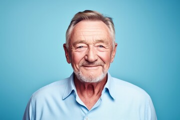 Portrait of a smiling senior man looking at camera against blue background