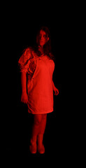 Seemingly innocent woman standing in the dark