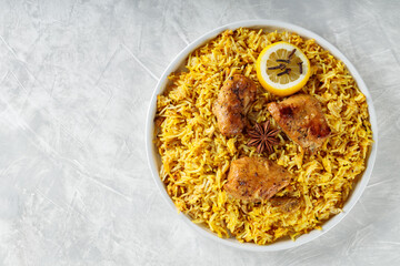 Indian Chicken Biryani with Basmati Rice, Star Anise, Cloves and Lemon on White Plate, Copy Space, Top View
