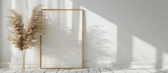 Thin wooden vertical frame mockup, sized 16x20, placed on a white wooden floor alongside a pampas grass prop.