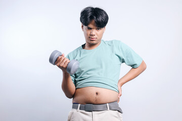 Asian man with fat belly holding dumbbell. Man diet lifestyle concept 