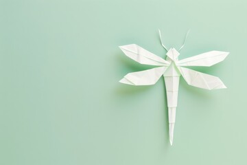 origami Dragonfly on pastel green background,