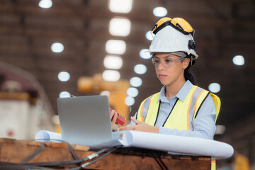 Portrait of railway technician worker in safety vest and helmet working with blueprint at train...