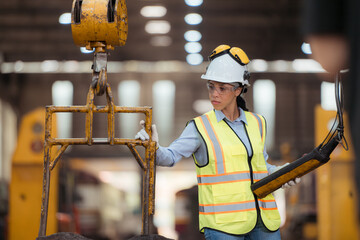 Portrait of railway technician worker in safety vest and helmet working at train repair station