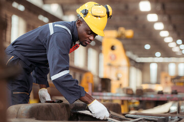 Railway technician in uniform and safety helmet working on train repair station